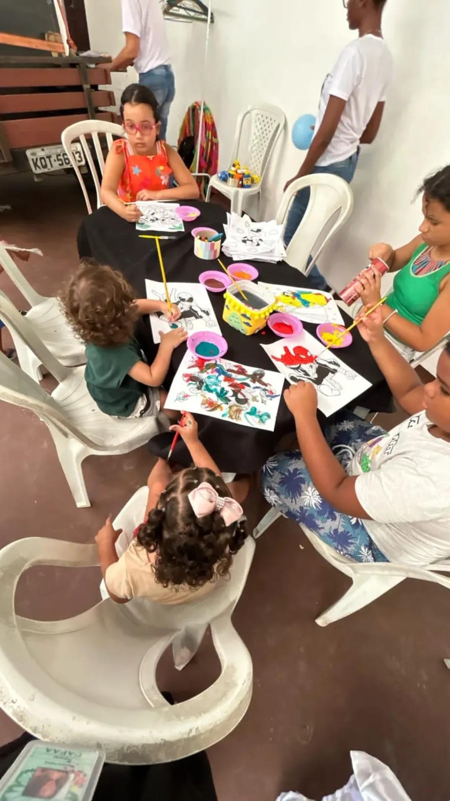 Crianças participam de uma atividade criativa acompanhadas pela equipe
