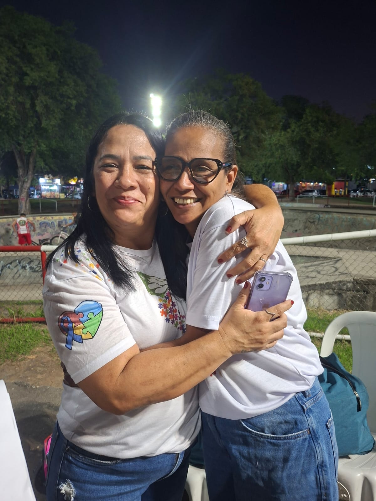 Duas integrantes da rede de apoio do CAFAA se abraçam durante um encontro